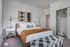 Chic bedroom with modern decor featuring cozy bed, stylish accent lighting, and spacious closet.