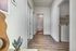 Inviting hallway showcasing modern laminate flooring with a view into a cozy laundry room and bathroom.