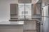 Modern kitchen with sleek cabinetry, granite countertops, and stainless steel appliances, bathed in natural light.