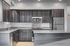 Modern kitchen with sleek dark wooden cabinetry, granite countertops, and stainless steel appliances.