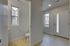 Modern apartment entrance with sleek wooden flooring and a well-lit compact bathroom offering a contemporary touch.
