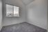 Bright, airy room with a plush carpet and large window presenting breathtaking mountain views.