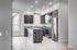 Modern kitchen with granite countertops, stainless steel appliances, and sleek dark wood cabinets in a bright, open space.