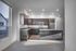 Modern kitchen with sleek dark wood cabinetry, stainless steel appliances, and granite countertops illuminated by recessed lighting.