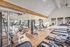 Bright, modern gym with state-of-the-art exercise equipment, featuring treadmills, weight machines, and mirrored walls.