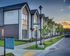 Contemporary townhomes at Hawthorne Residences featuring modern design, lush greenery, and a serene suburban setting at sunset.