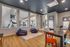 Inviting multi-purpose room with vibrant chairs, playful bean bags, and a view into a modern fitness center.