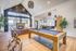 Luxurious open-concept entertainment area with a stylish pool table, sleek kitchen, and cozy seating by a modern fireplace.