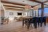 Stylish open-plan living area featuring modern wooden beams, elegant lighting, and floor-to-ceiling windows with city views.