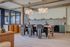 Elegant open-plan dining area with a stylish wooden table, chic chairs, modern pendant lighting, and expansive windows for natural light.