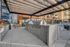 Modern outdoor kitchen area with sleek stainless steel grills under a stylish pergola, perfect for entertaining.