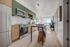 Bright, modern kitchen with cabinetry, stainless steel appliances, and a stylish dining area featuring natural light and sleek hardwood floors.
