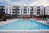 Luxury apartment complex with modern architecture featuring a refreshing swimming pool and vibrant poolside lounges.