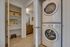 Modern apartment showcasing a convenient in-unit washer and dryer beside a spacious shelving unit and elegant bathroom view.