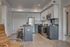 Modern open-concept kitchen with sleek appliances, stylish island seating, and elegant wood flooring.