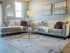 Inviting living room with plush taupe sofas, elegant glass coffee table, and chic modern decor, perfect for relaxation.