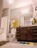 Modern bathroom with elegant vanity, stylish lighting, and vibrant towel accents, creating a fresh and inviting atmosphere.