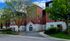 Charming red-brick apartment complex surrounded by lush greenery, featuring a welcoming entrance and modern architectural design.