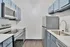 Contemporary kitchen with sleek stainless steel appliances, stylish blue cabinetry, and elegant wood flooring.
