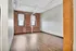Contemporary loft apartment showcasing exposed brick walls, large windows with city views, and sleek hardwood flooring.