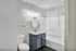 Contemporary bathroom with sleek finishes, featuring a stylish vanity, modern fixtures, and a pristine bathtub in a bright, inviting space.