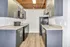 Contemporary kitchen with sleek dark cabinetry, polished countertops, and modern appliances in a stylish apartment.