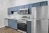 Modern kitchen with sleek blue cabinetry, stainless steel appliances, and elegant wood flooring.