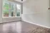 Bright and airy room featuring large windows with tree views and elegant wood flooring.
