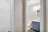 Inviting bathroom with elegant blue cabinetry, modern fixtures, and a spacious closet nearby.