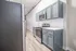Modern kitchen with sleek stainless steel appliances, elegant gray cabinetry, and contemporary white tile backsplash.