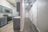 Modern apartment hallway featuring sleek cabinetry and stylish kitchen with stainless steel appliances.