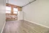 Charming room with exposed brick walls, large windows, and elegant wood flooring, perfect for a cozy apartment setting.