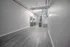 Modern open-concept apartment with sleek hardwood floors and industrial-style exposed ductwork, featuring a stylish kitchen with stainless steel appliances.