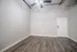 Modern room with sleek wooden floors, neutral walls, and a ceiling fan, perfect for a cozy living space.