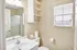Bright and inviting bathroom featuring a modern sink, glass shower door, and ample natural light through a window with blinds.