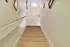 Inviting carpeted staircase leading to a bright, serene upper hallway in a charming home.