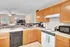 Bright and inviting kitchen featuring warm wood cabinets, modern appliances, and open flow to cozy living area with ceiling fan and stylish decor.
