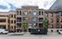 Elegant urban apartment building with classic brick facade and arched windows, offering modern leasing opportunities.