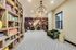 Elegant lounge area featuring plush green seating, a chic chandelier, vibrant floral mural, and stylish geometric flooring.