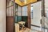 Charming vintage elevator space with elegant green paneling, warm lighting, and stylish decor accents.