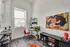 Contemporary reading nook with vibrant artwork, stylish shelving, and lush potted plants, perfect for creative inspiration.
