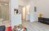 Bright and modern apartment interior featuring sleek wooden flooring, a stylish bathroom with a glass shower, and vibrant decor accents bringing a cheerful touch.