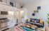 Charming open-plan studio boasting a modern kitchenette, cozy lounge with colorful accents, and in-unit washer and dryer.