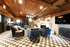 Chic lounge area with rustic wooden ceilings, modern lighting, and stylish seating, perfect for entertaining.