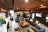 Chic and inviting apartment lounge with a rustic wood ceiling, vibrant checkered flooring, cozy seating areas, and stylish d&eacute;cor accents.