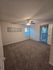 Bright and inviting bedroom with plush carpeting, ceiling fan, and large windows for natural light.