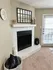 Cozy living room corner featuring a stylish tiled fireplace, decorative candles, and a modern mirrored wall accent.