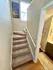 Inviting carpeted staircase leading to a bright upper level, paired with a stylish bathroom featuring modern amenities.