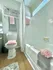 Bright, modern bathroom with elegant white tiles, cozy decor, and plush pink accents. Perfect for relaxation.