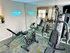 Modern home gym with state-of-the-art exercise equipment, motivational neon sign, and mirrored walls for an inspiring workout space.